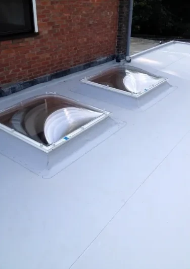 Plat dak in PVC met twee lichtkoepels